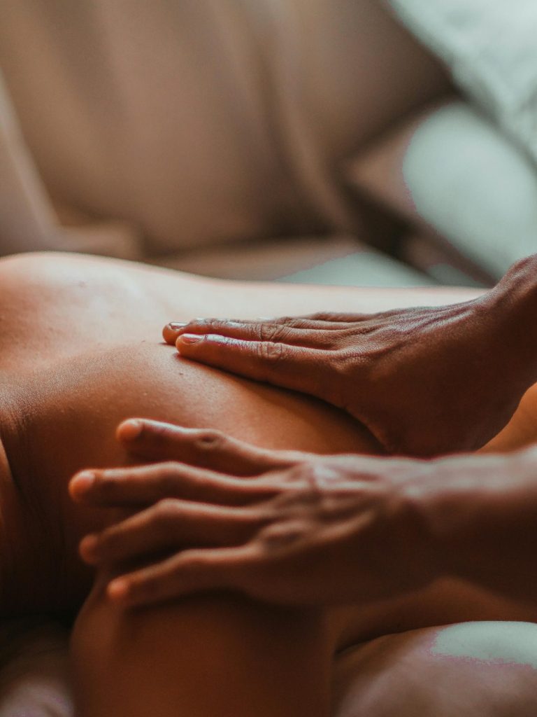 Deux mains posées sur un dos allongé pour représenter la guidance autour du cycle menstruel basée sur le Shiatsu selon Shen Dao